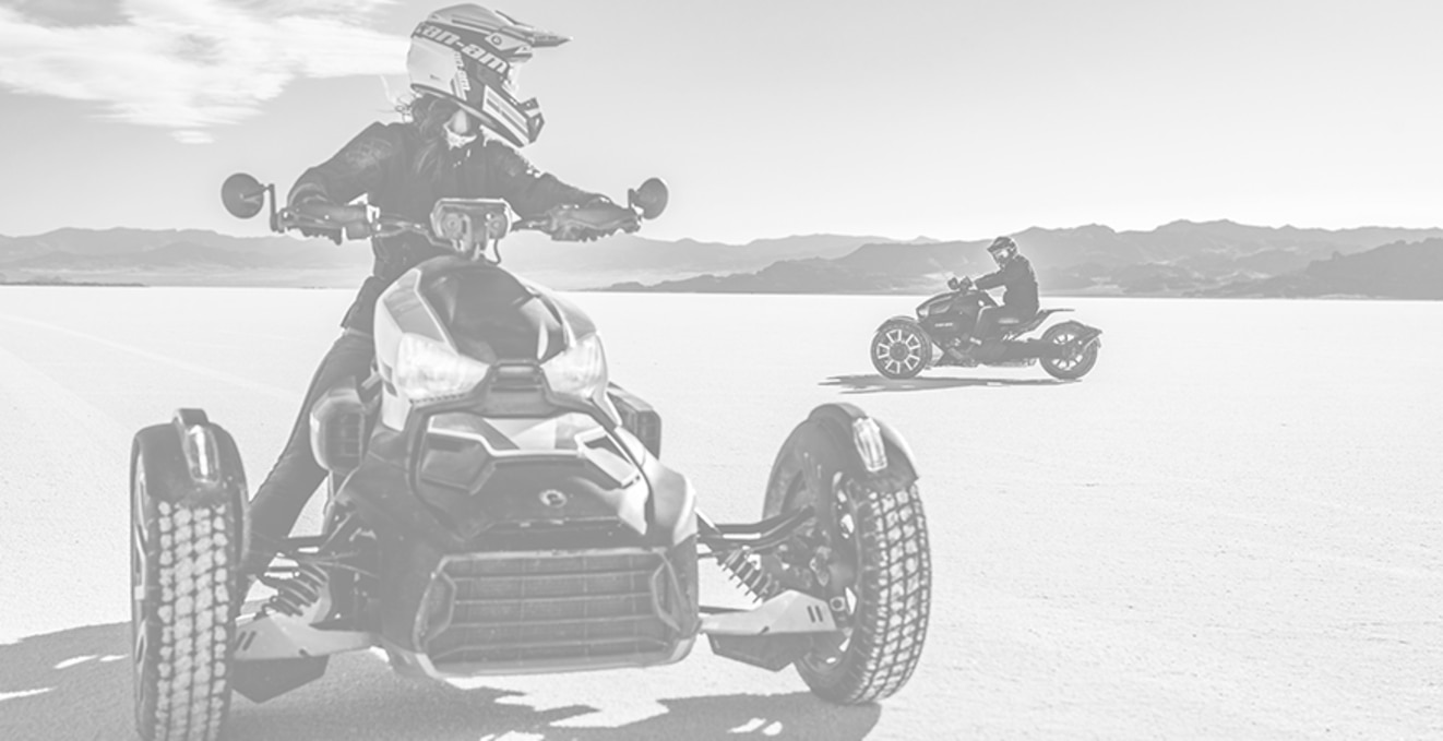 Two riders riding Can-Am 3-wheel motorcycle in the desert